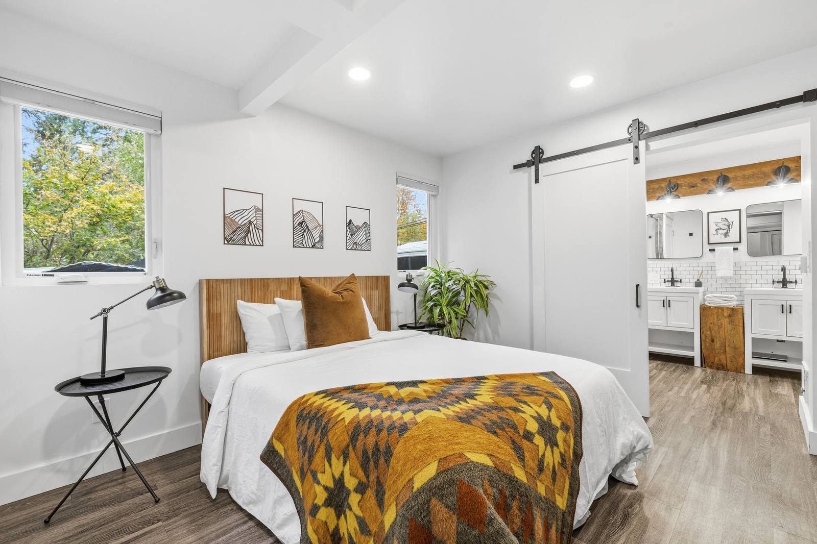 Bedroom with a sliding barn door leading to the bathroom in a Stay Flourish-managed Bothell short-term rental