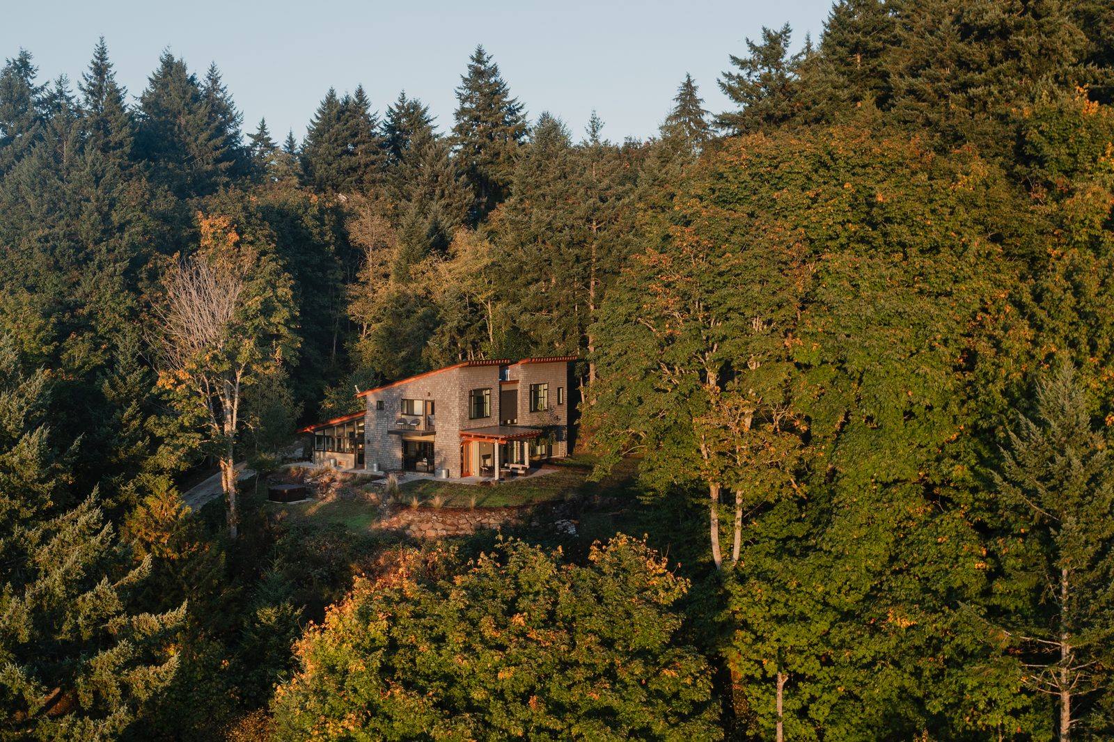 Twilight exterior of a King County short-term rental with string lights and outdoor seating on the deck